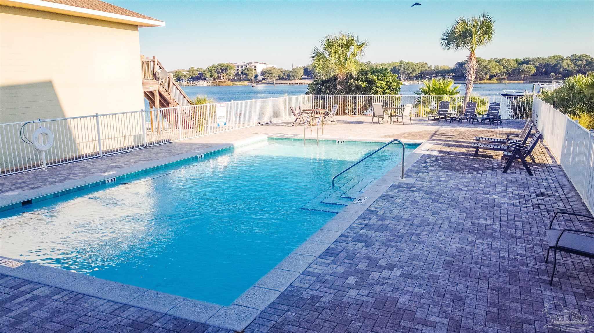 340 Bluefish Drive, Unit 206 Fort Walton Beach, FL 32548 - Photo 15 of 43 a view of a swimming pool with a lounge chairs