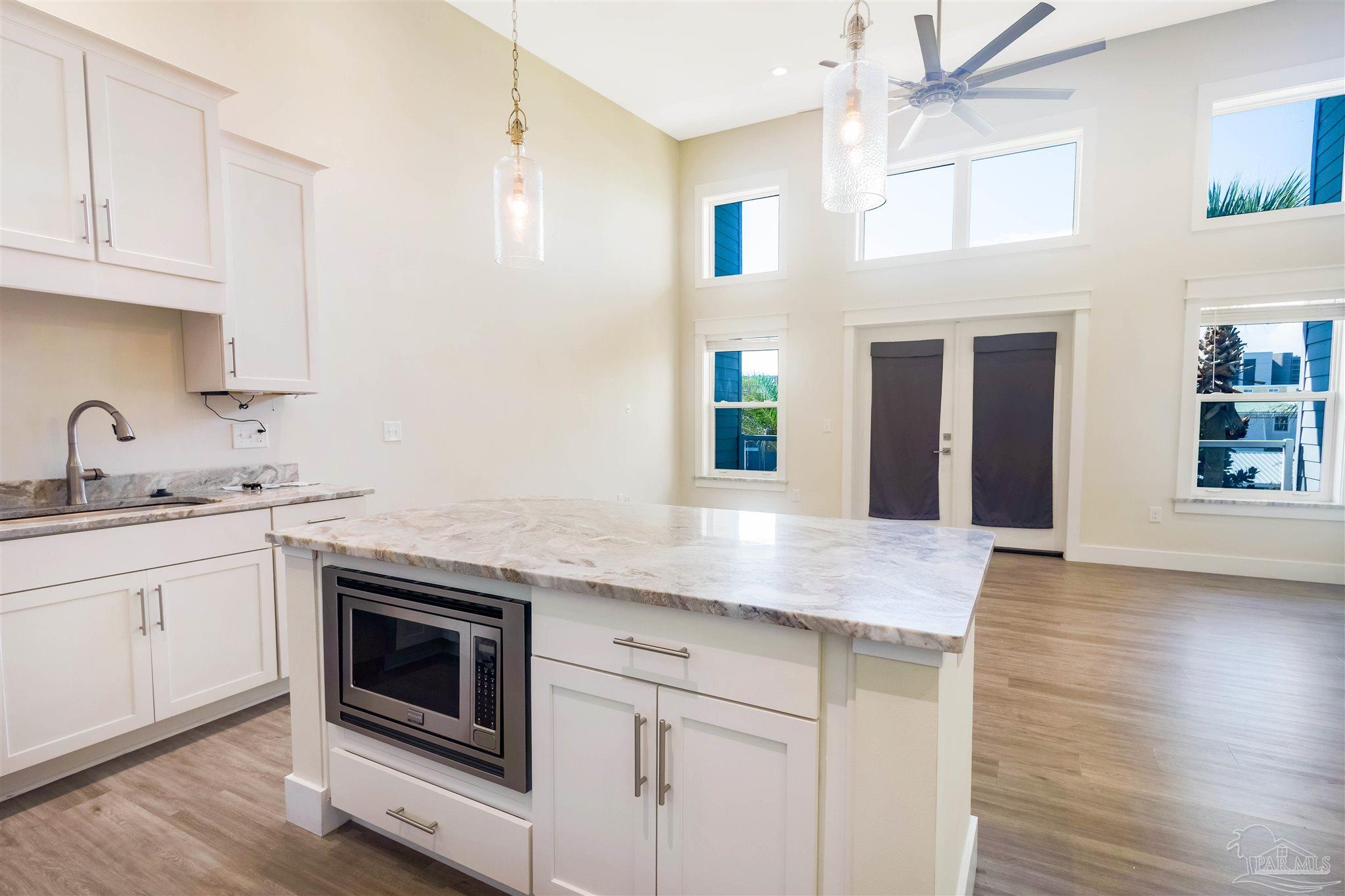 340 Bluefish Drive, Unit 206 Fort Walton Beach, FL 32548 - Photo 18 of 43 a kitchen with stainless steel appliances granite countertop a sink and cabinets with wooden floor