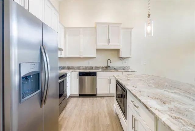 a kitchen with stainless steel appliances wooden floors and wooden cabinets