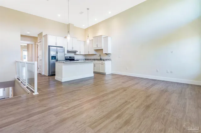 a kitchen with stainless steel appliances a stove top oven a sink and white cabinets