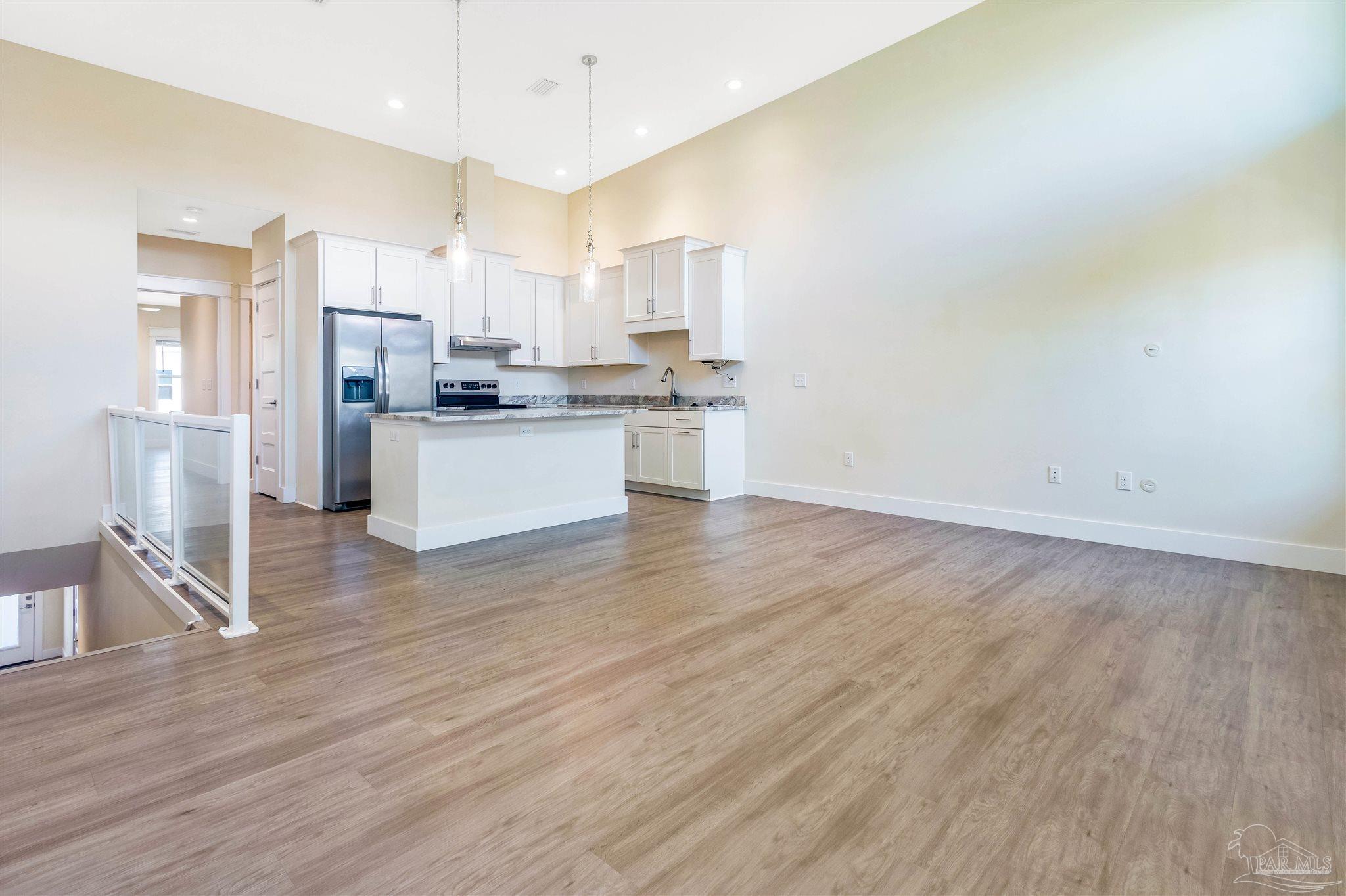 340 Bluefish Drive, Unit 206 Fort Walton Beach, FL 32548 - Photo 22 of 43 a kitchen with stainless steel appliances wooden floors and wooden cabinets