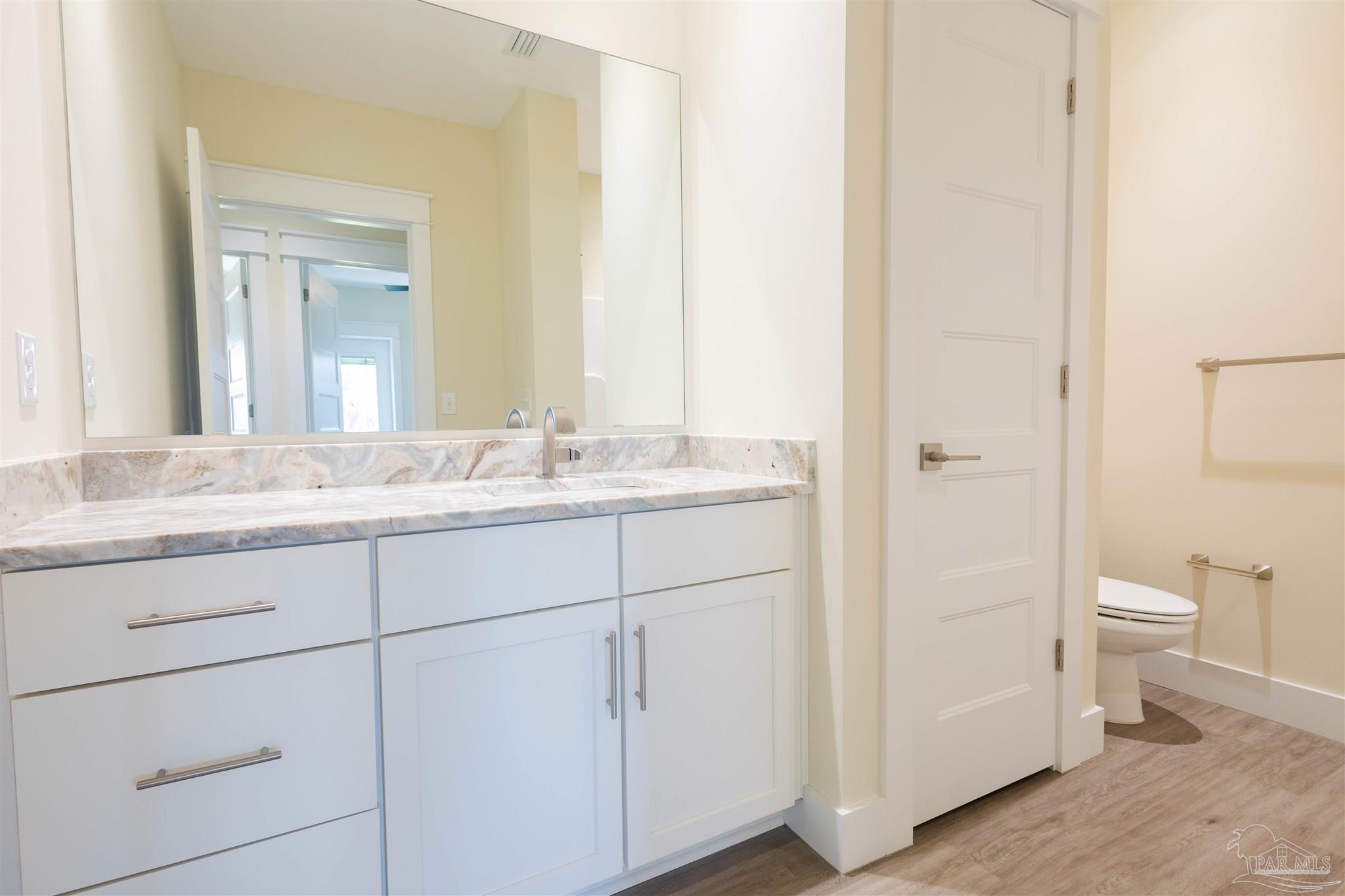 340 Bluefish Drive, Unit 206 Fort Walton Beach, FL 32548 - Photo 28 of 43 a bathroom with a toilet a sink and a mirror