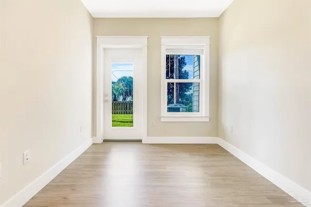 a view of a small space with wooden floor and a window