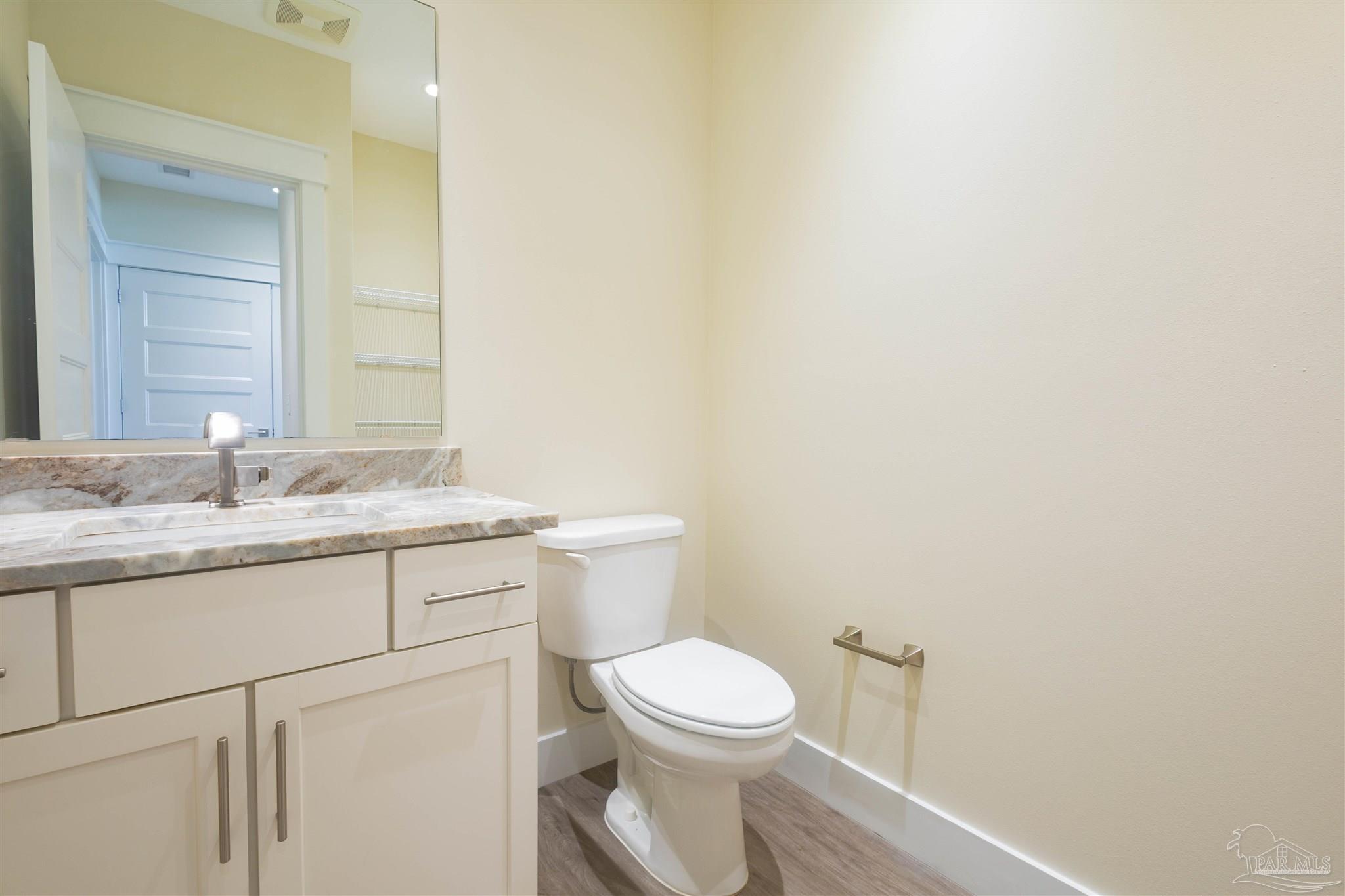 340 Bluefish Drive, Unit 206 Fort Walton Beach, FL 32548 - Photo 36 of 43 a bathroom with a granite countertop toilet a sink and a mirror