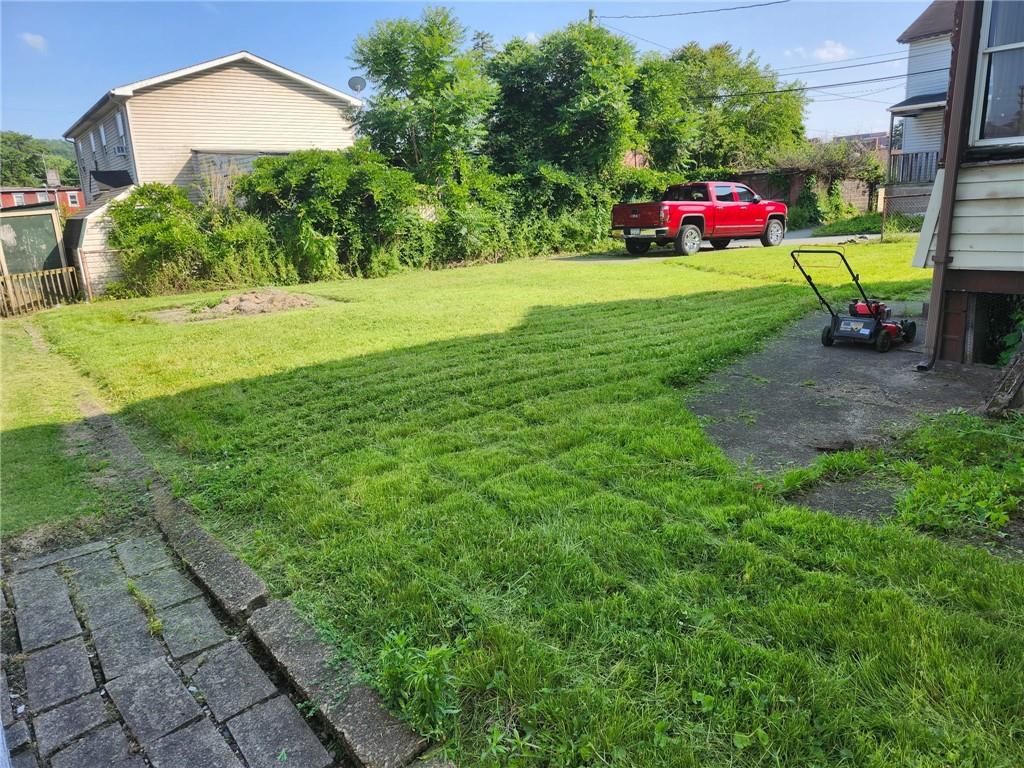 58 Elm Street Natrona Heights, PA 15065 - Photo 3 of 23 a view of a fire pit in front of a brick house with a small yard