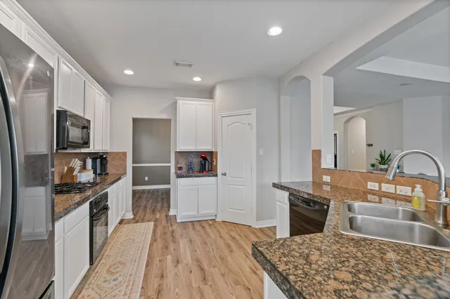 a kitchen with stainless steel appliances granite countertop a sink stove and refrigerator