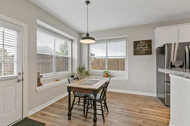 a dining room with furniture a chandelier and wooden floor
