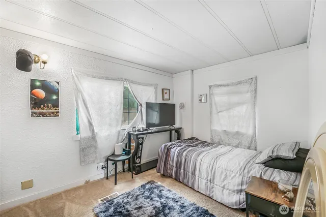 a bedroom with a bed a couch and a large window