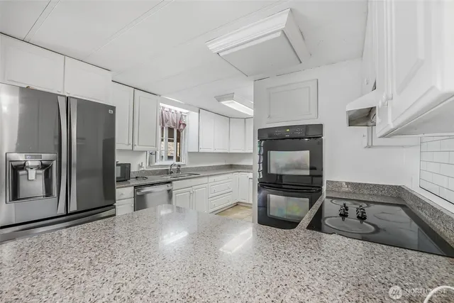 a kitchen with stainless steel appliances granite countertop a refrigerator and a sink