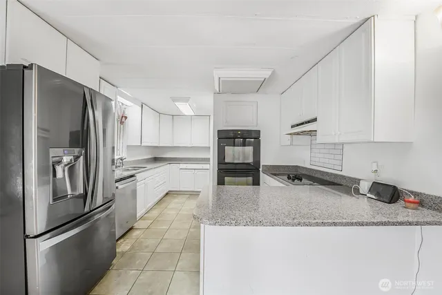 a kitchen with granite countertop a refrigerator and a sink
