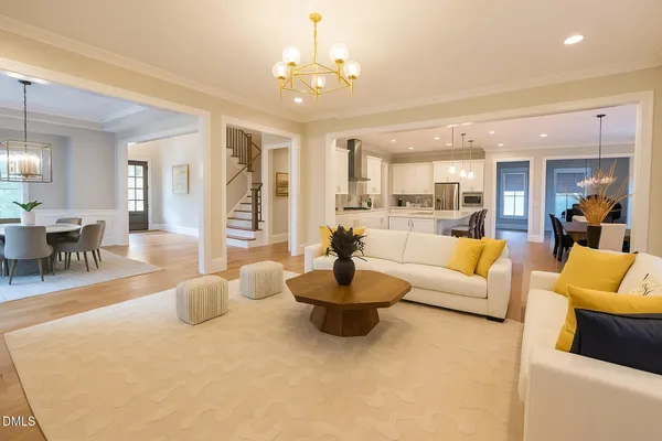 a living room with furniture wooden floor and floor to ceiling windows
