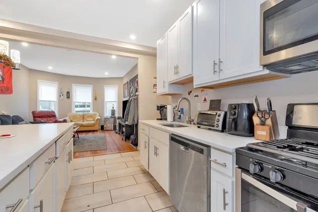 a kitchen with white cabinets and appliances