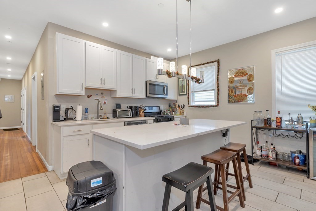 228 Calumet Street, Unit 1 Boston, MA 02120 - Photo 2 of 14 a kitchen with a sink white cabinets and appliances