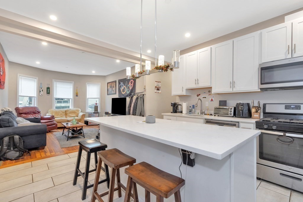228 Calumet Street, Unit 1 Boston, MA 02120 - Photo 3 of 14 a large white kitchen with stainless steel appliances