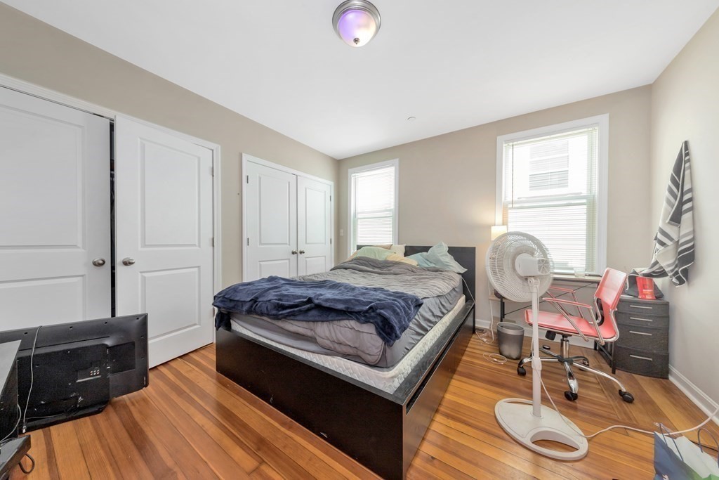 228 Calumet Street, Unit 1 Boston, MA 02120 - Photo 9 of 14 a bedroom with a bed and wooden floor