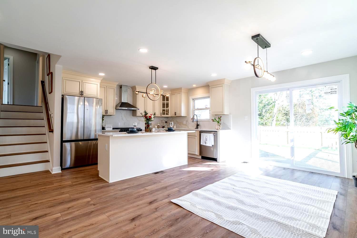 1009 Edgemoor Road Cherry Hill, NJ 08034 - Photo 15 of 49 a kitchen with stainless steel appliances kitchen island granite countertop a refrigerator a sink dishwasher a stove and a dining table with wooden floor