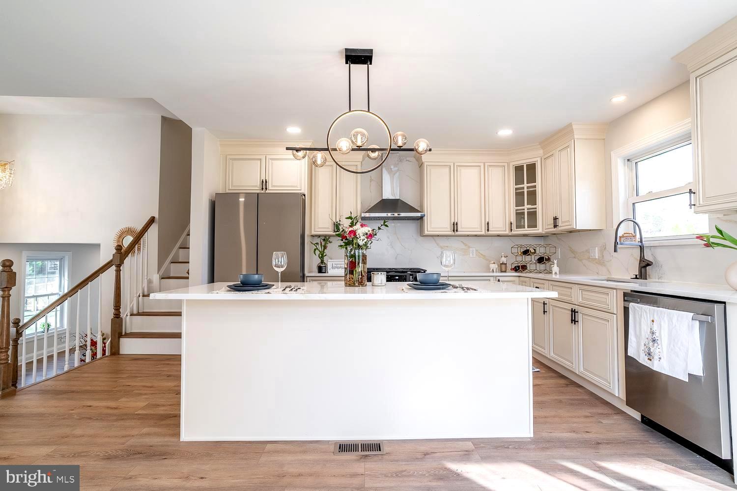 1009 Edgemoor Road Cherry Hill, NJ 08034 - Photo 16 of 49 a kitchen with kitchen island granite countertop wooden floors and white cabinets