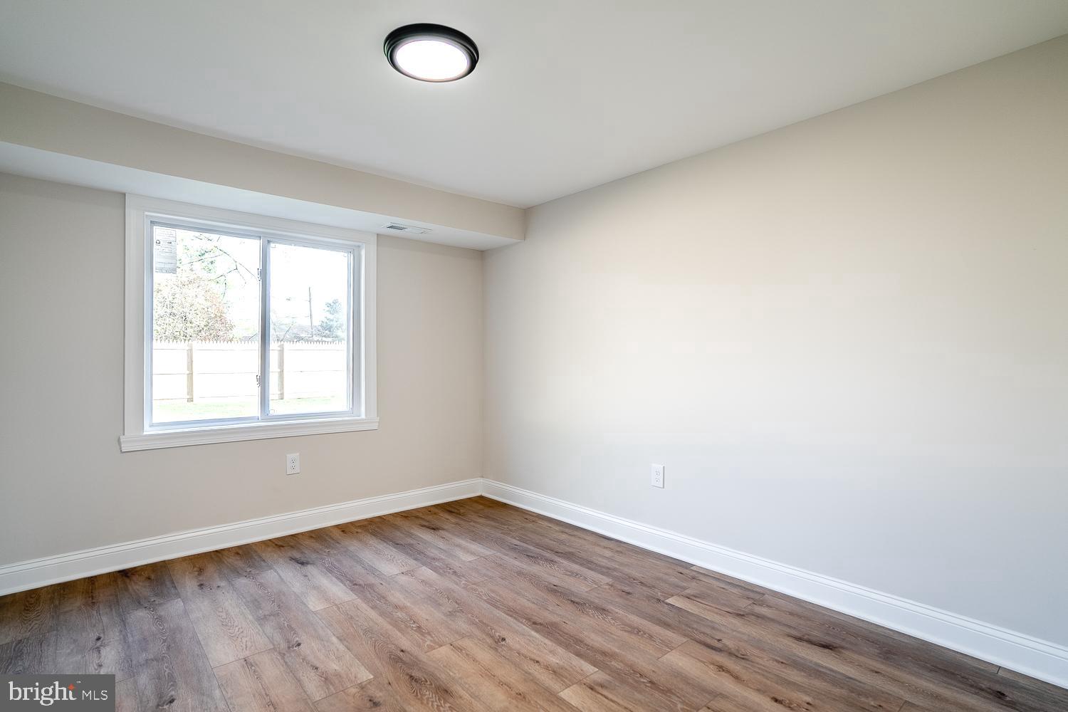 1009 Edgemoor Road Cherry Hill, NJ 08034 - Photo 8 of 49 an empty room with wooden floor and windows