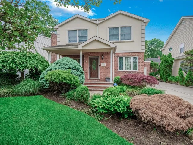a front view of a house with a garden and plants