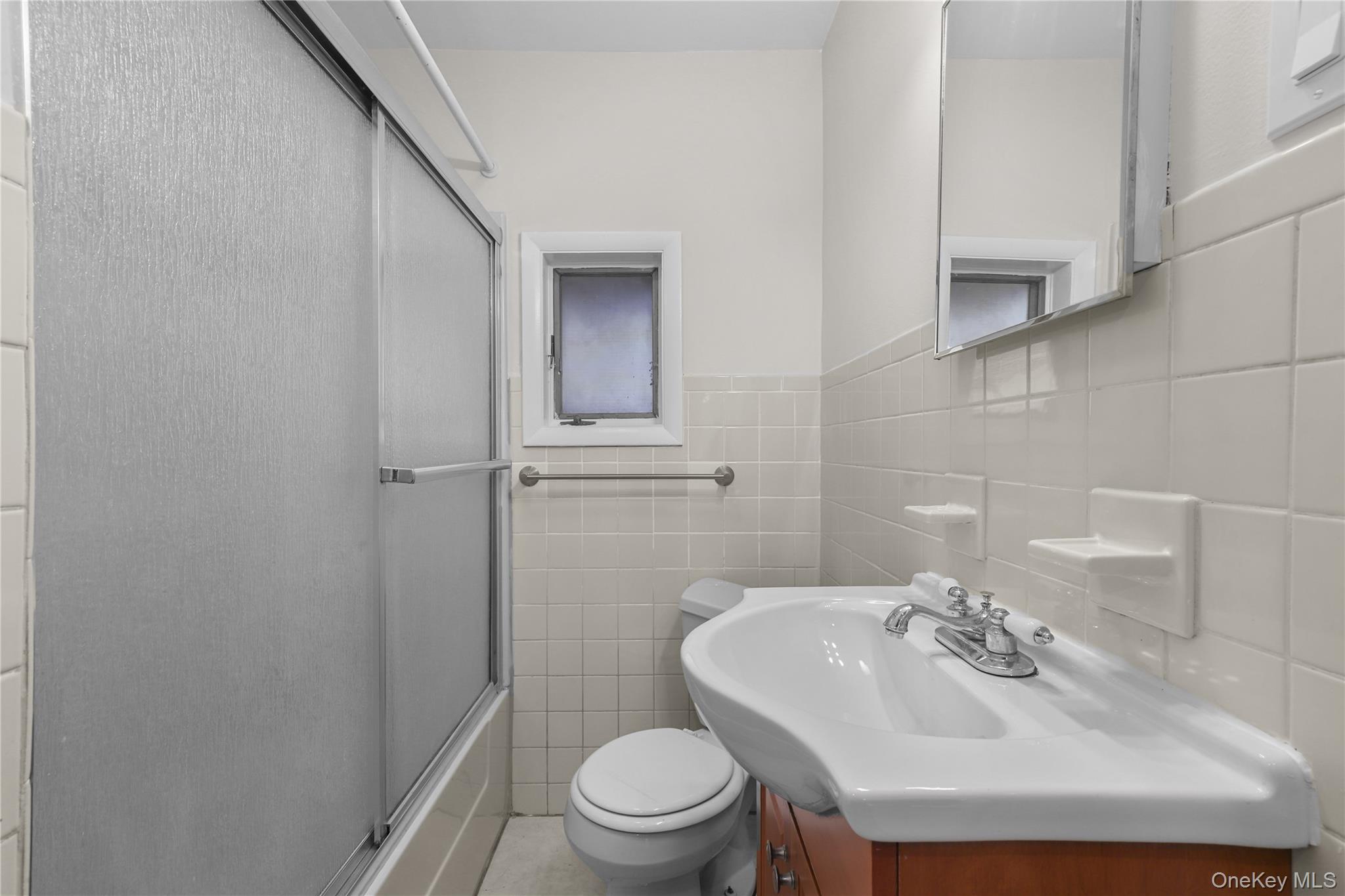 8 Virginia Avenue, Unit 1 Dobbs Ferry, NY 10522 - Photo 7 of 16 a bathroom with a sink a toilet and a mirror