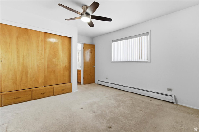 217 East 400 South Spring City, UT 84662 - Photo 24 of 71 Unfurnished bedroom featuring baseboard heating, a closet, light colored carpet, and ceiling fan