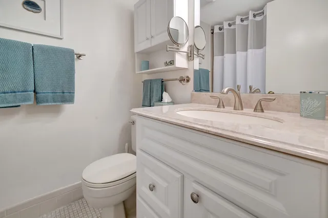 a bathroom with a sink a toilet and a mirror