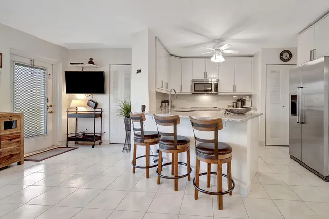 a kitchen with refrigerator and chairs