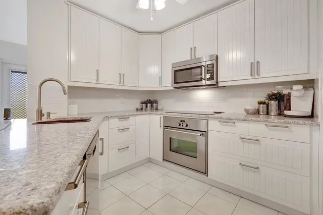 a kitchen with white cabinets and appliances