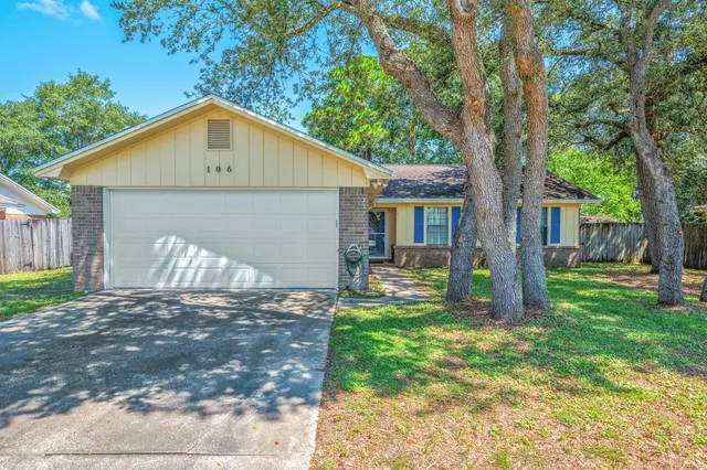 a view of a house with a yard and tree s