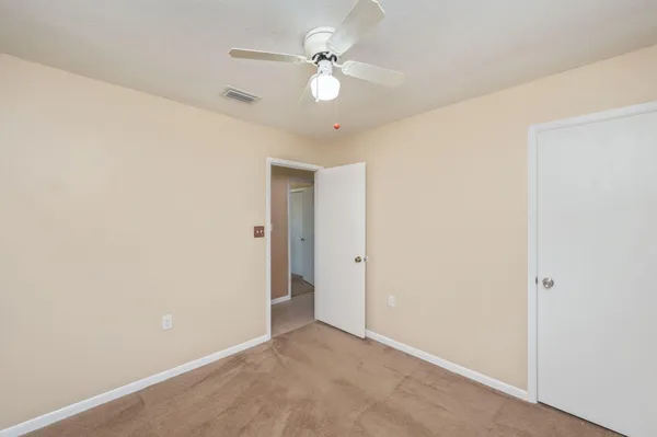an empty room with a ceiling fan and a window