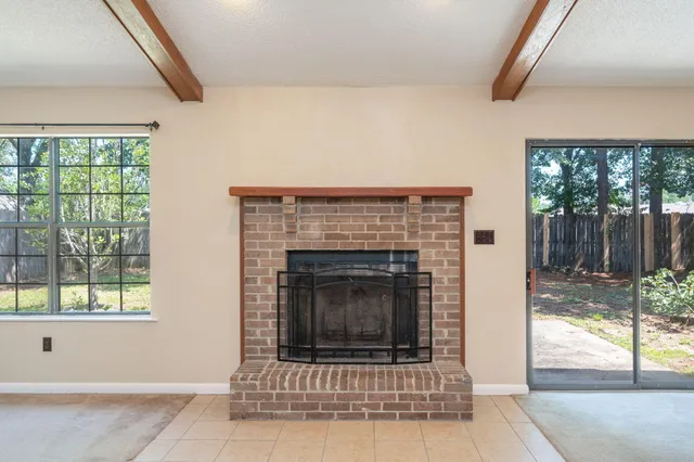 a living room with a fireplace and a floor to ceiling window
