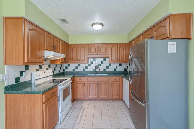 a kitchen with stainless steel appliances granite countertop a refrigerator and a sink