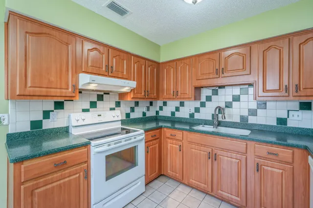 a kitchen with granite countertop a stove sink and cabinets