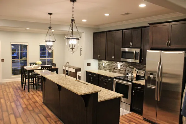 a kitchen with granite countertop a sink appliances and cabinets