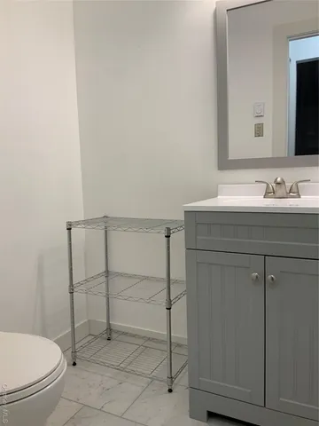 a bathroom with a toilet a sink and mirror