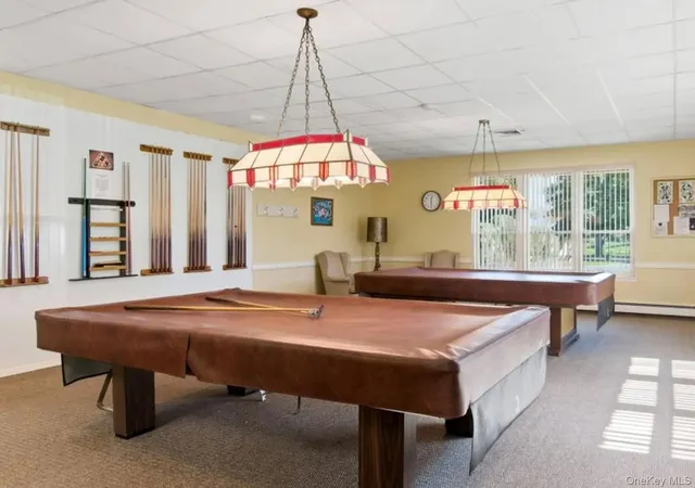 a room with pool table and windows