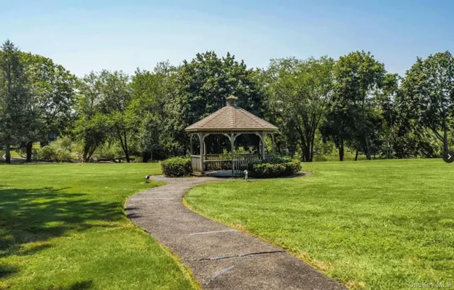 a front view of a house with garden and trees