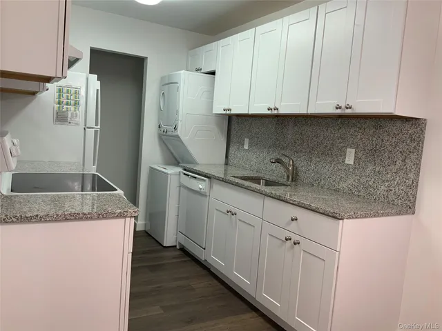 a kitchen with granite countertop a sink and cabinets