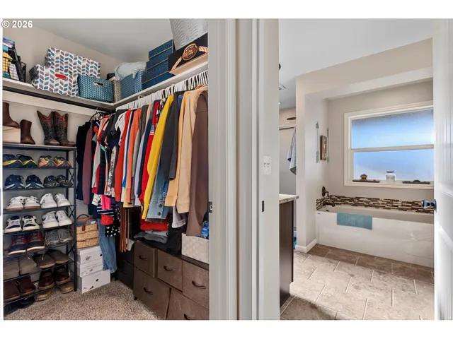 a view of walk in closet with clothes and shoes