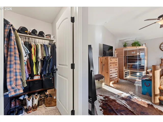 a view of walk in closet with clothes and shoes