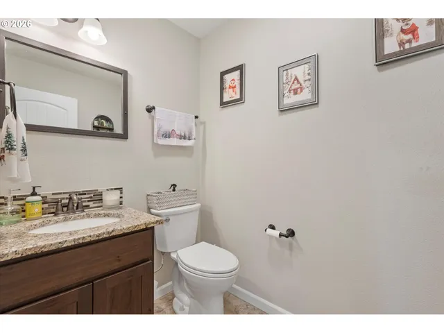 a bathroom with a granite countertop toilet a sink and mirror