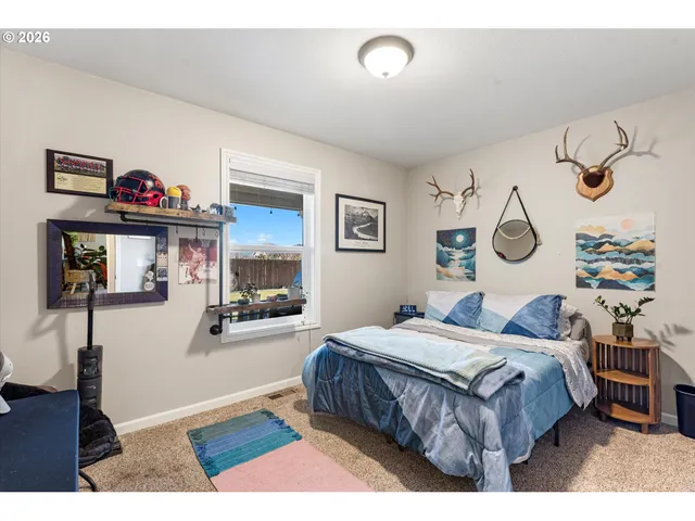 a bedroom with a bed a table and painting