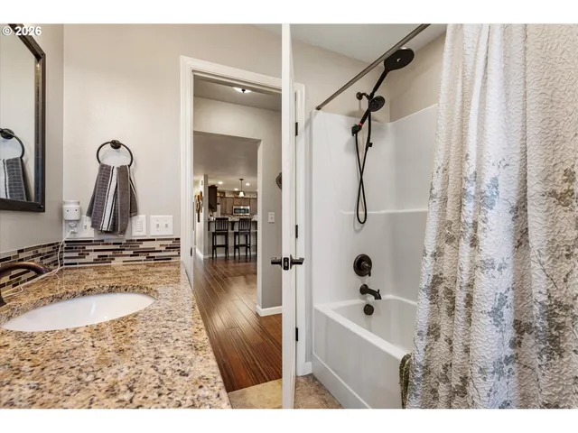 a bathroom with a granite countertop sink mirror and shower