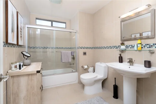 a bathroom with a sink mirror toilet and bathtub