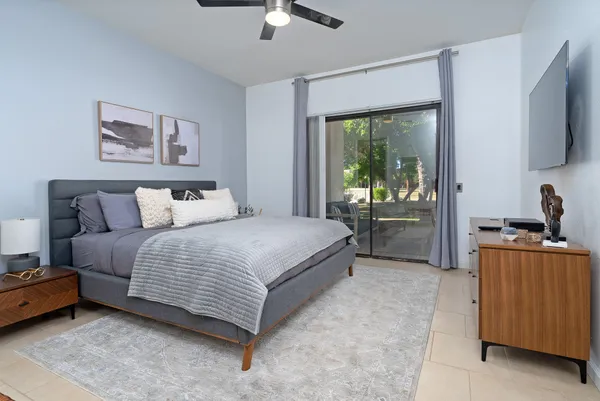 a bedroom with a balcony a bed and a flat screen tv