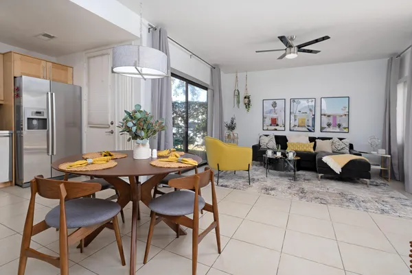 a living room with furniture kitchen view and a window