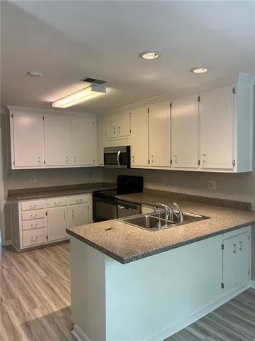 a kitchen with granite countertop a sink a stove and cabinets