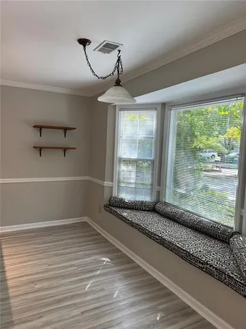 a view of a room with wooden floor and windows