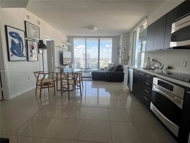 a kitchen with stainless steel appliances granite countertop a stove a sink a dining table and chairs