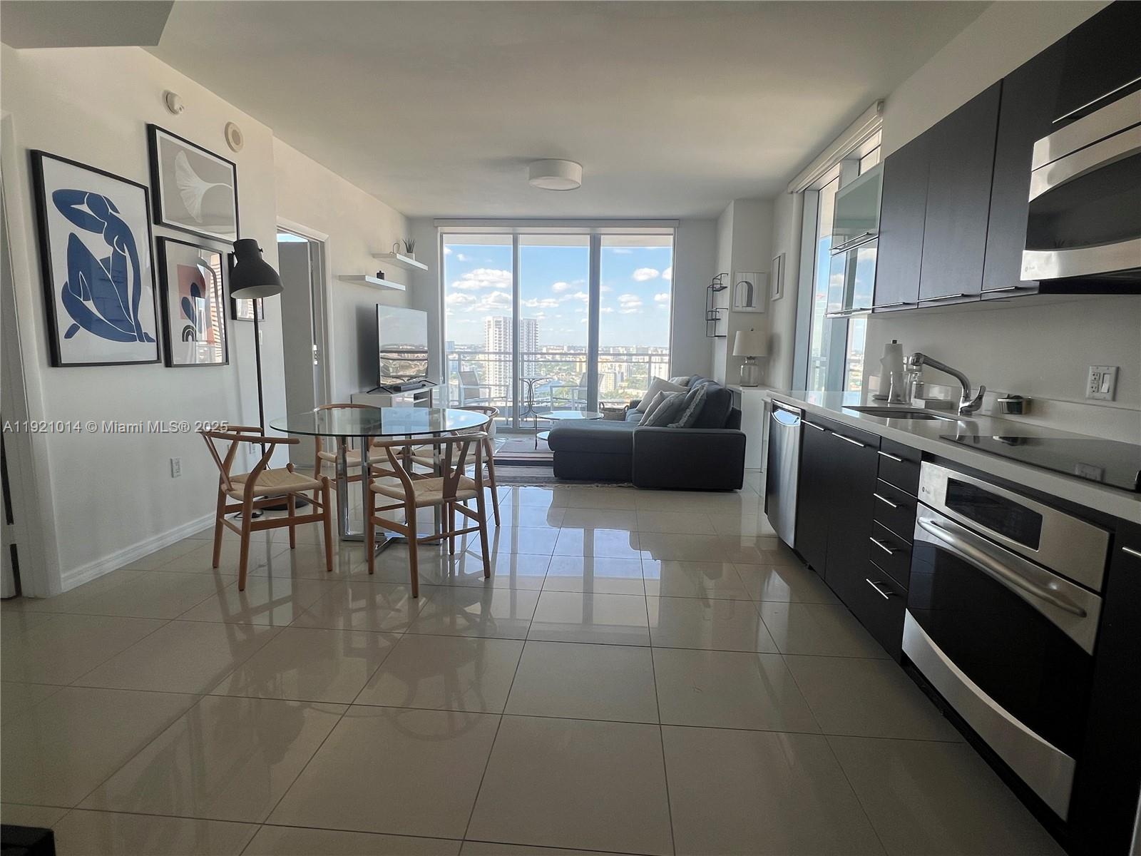 90 Southwest 3rd Street, Unit 2605 Miami, FL 33130 - Photo 3 of 15 a kitchen with stainless steel appliances granite countertop a stove a sink a dining table and chairs